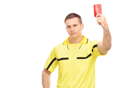 Strict football referee standing and showing a red card isolated on white backgroundの写真素材