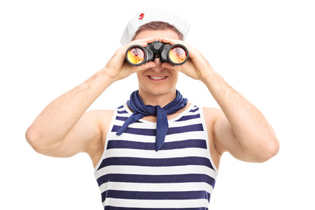 Portrait of a young male sailor looking through binoculars isolated on white backgroundの写真素材