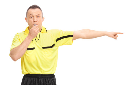 Angry football referee blowing a whistle and pointing with his hand isolated on white backgroundの写真素材