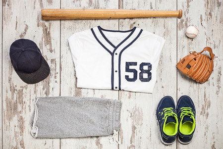 Bunch of sportswear and baseball equipment on a white hardwood floorの写真素材