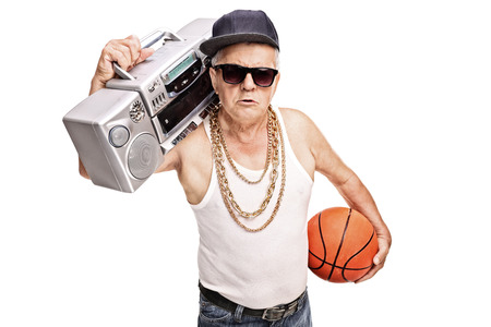 Senior man in hip hop outfit holding a ghetto blaster and a basketball isolated on white backgroundの写真素材
