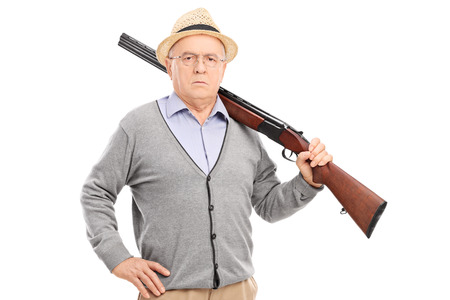 Senior gentleman posing with a rifle isolated on white backgroundの写真素材