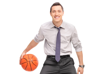 Young businessman playing basketball and looking at the camera isolated on white backgroundの写真素材