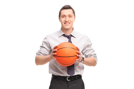Young businessman holding a basketball and looking at the camera isolated on white backgroundの写真素材