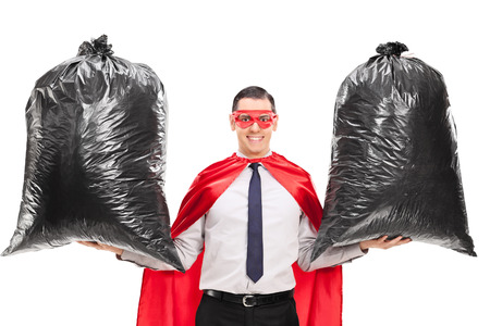 young superhero holding two trash bags isolated on white backgroundの写真素材