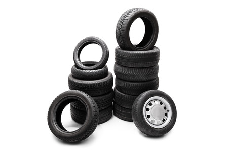 Studio shot of  black car tires piled up in two separate stacks isolated on white backgroundの写真素材
