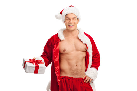 Handsome man with unbuttoned Santa Claus costume holding a present and looking at the camera isolated on white backgroundの写真素材