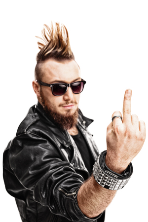Vertical shot of a young punk rocker showing his middle finger towards the camera isolated on white backgroundの写真素材