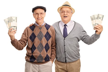 Tow senior gentlemen holding several stacks of money and posing together isolated on white backgroundの写真素材