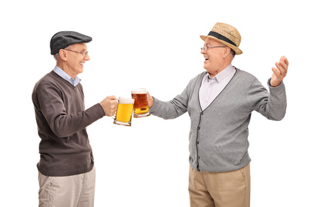 Two cheerful seniors drinking beer and having a conversation isolated on white backgroundの写真素材