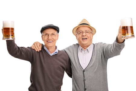 Studio shot of two cheerful seniors holding pints of beer and celebrating isolated on white backgroundの写真素材
