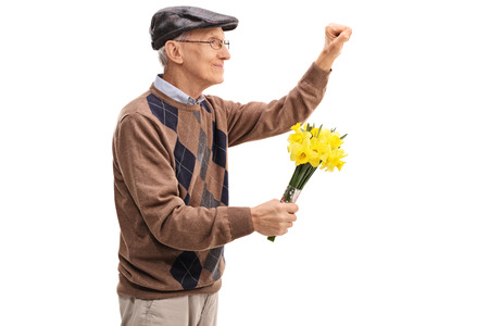 Senior holding flowers and preparing to knock on a door isolated on white backgroundの写真素材