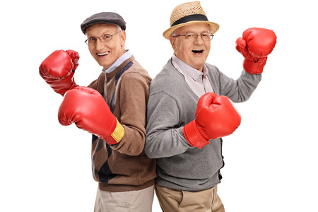 Two senior gentlemen posing together with boxing gloves isolated on white backgroundの写真素材