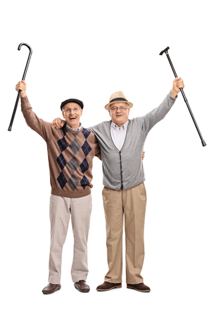 Full length portrait of two senior gentlemen posing together and celebrating something isolated on white backgroundの写真素材