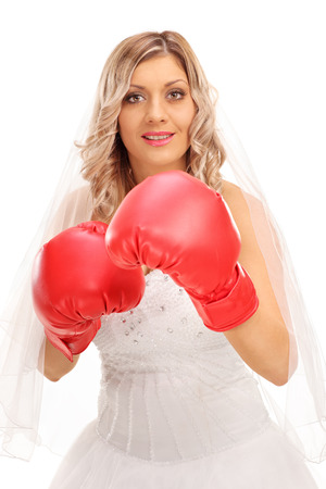 Vertical shot of a cheerful bride with red boxing gloves isolated on white backgroundの写真素材