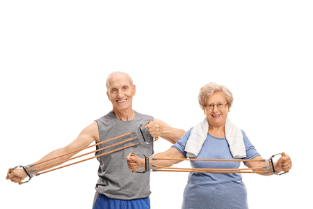 Senior man and woman exercising with a resistance band isolated on white backgroundの写真素材