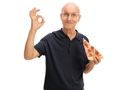 Elderly man having a slice of pizza and making an ok sign isolated on white backgroundの写真素材
