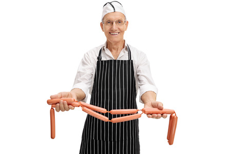 Senior butcher showing some raw sausages isolated on white backgroundの写真素材
