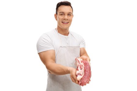 Young butcher offering a beef steak isolated on white backgroundの写真素材