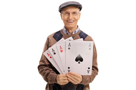 Cheerful mature man holding four aces isolated on white background