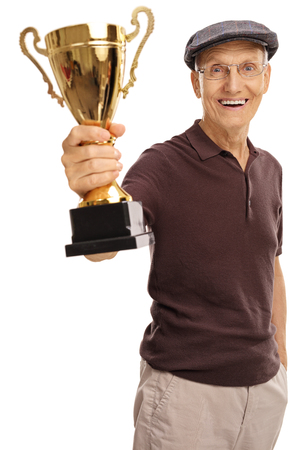 Delighted elderly man holding a golden trophy isolated on white backgroundの写真素材