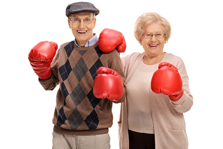 Joyful seniors posing with boxing gloves isolated on white backgroundの写真素材