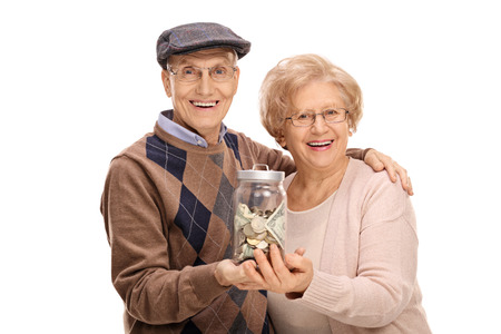 Joyful seniors holding a jar with money isolated on white backgroundの写真素材