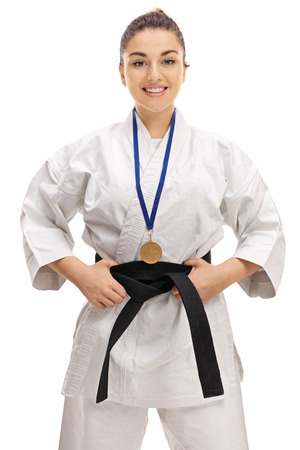 Karate girl with a gold medal smiling and looking at the camera isolated on white backgroundの写真素材