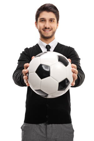 Young man handing a football towards the camera isolated on white backgroundの写真素材