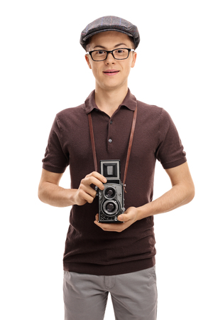 Teenage boy with a vintage outfit and an old camera isolated on white backgroundの写真素材