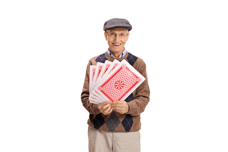 Senior with playing cards looking at the camera and smiling isolated on white background