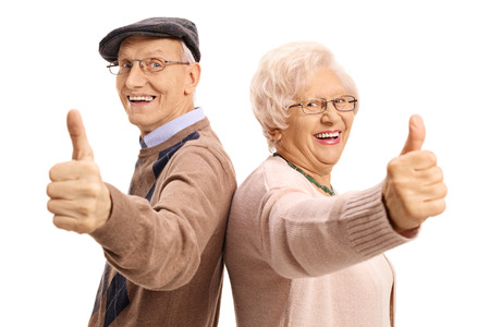Cheerful seniors holding their thumbs up isolated on white background