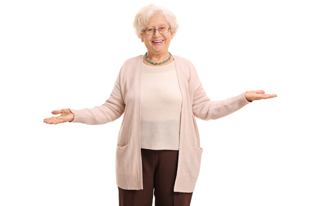 Cheerful elderly woman gesturing with her hands and looking at the camera isolated on white backgroundの写真素材
