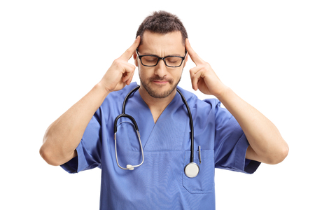 Doctor having a headache and touching his temples isolated on white backgroundの写真素材