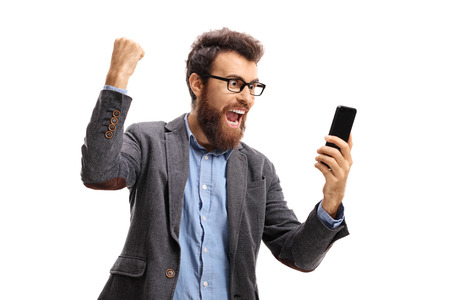 Bearded man with a phone gesturing happiness isolated on white backgroundの写真素材