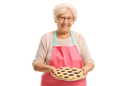 Elderly woman with freshly baked pie isolated on white backgroundの写真素材