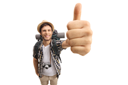 Tourist making a thumb up gesture and smiling isolated on white backgroundの写真素材