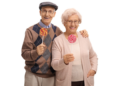 Senior couple with lollipops isolated on white backgroundの写真素材