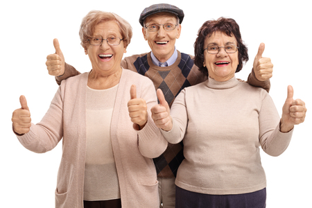 Joyful seniors holding their thumbs up isolated on white backgroundの写真素材