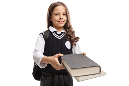 Little schoolgirl giving books isolated on white backgroundの写真素材