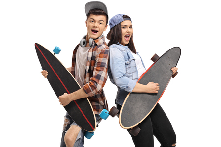 Joyful teenagers pretending to play guitar on longboards isolated on white backgroundの写真素材