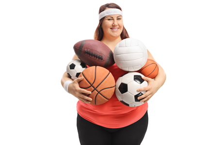 Overweight woman holding different kinds of sports balls isolated on white backgroundの写真素材
