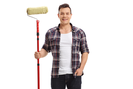 Young man holding a paint roller isolated on white backgroundの写真素材