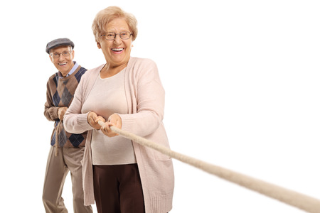 Elderly couple pulling a rope isolated on white backgroundの写真素材