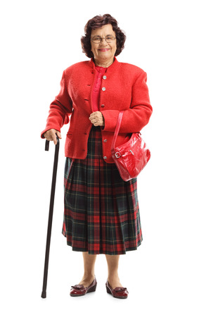 Full length portrait of a senior lady in a red suit isolated on white backgroundの写真素材