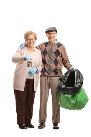 Full length portrait of an elderly couple with a tin can and a garbage bag isolated on white backgroundの写真素材