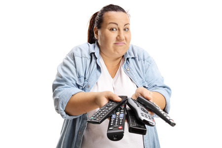 Confused woman holding a bunch of remotes isolated on white background