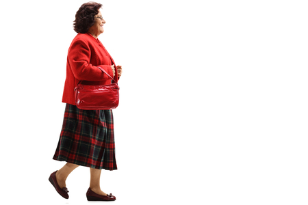Full length profile shot of a senior lady walking isolated on white backgroundの写真素材
