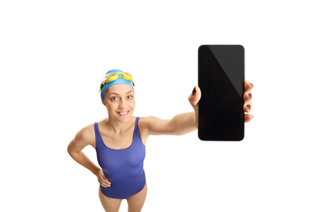 Young woman in a swimming suit holding a mobile phone isolated on white backgroundの写真素材