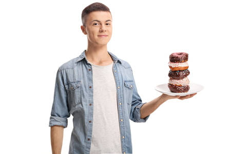 Teenage boy holding a plate of donuts isolated on white backgroundの写真素材